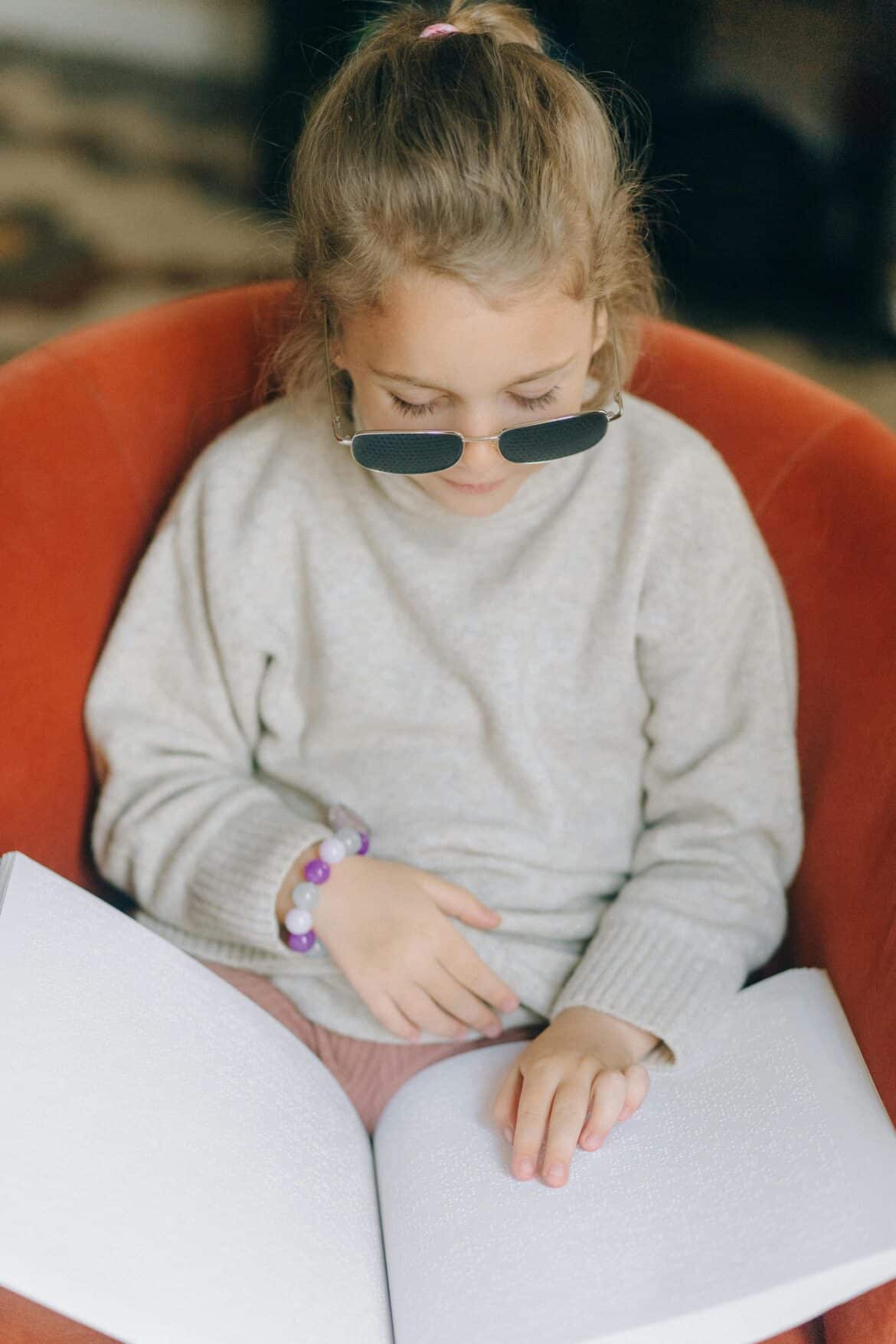 A blind girl reading braille book