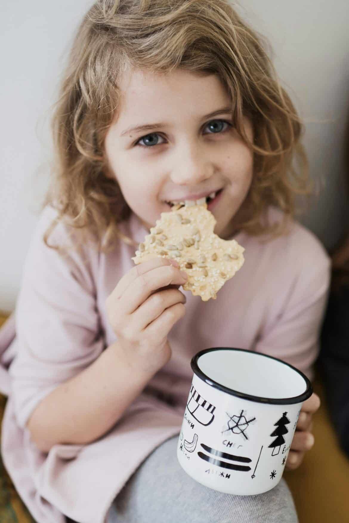 Girl eating biscuit and milk