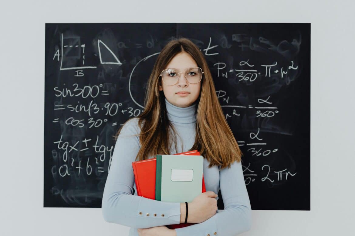 Portrait of a female student standing in front of a blackboard