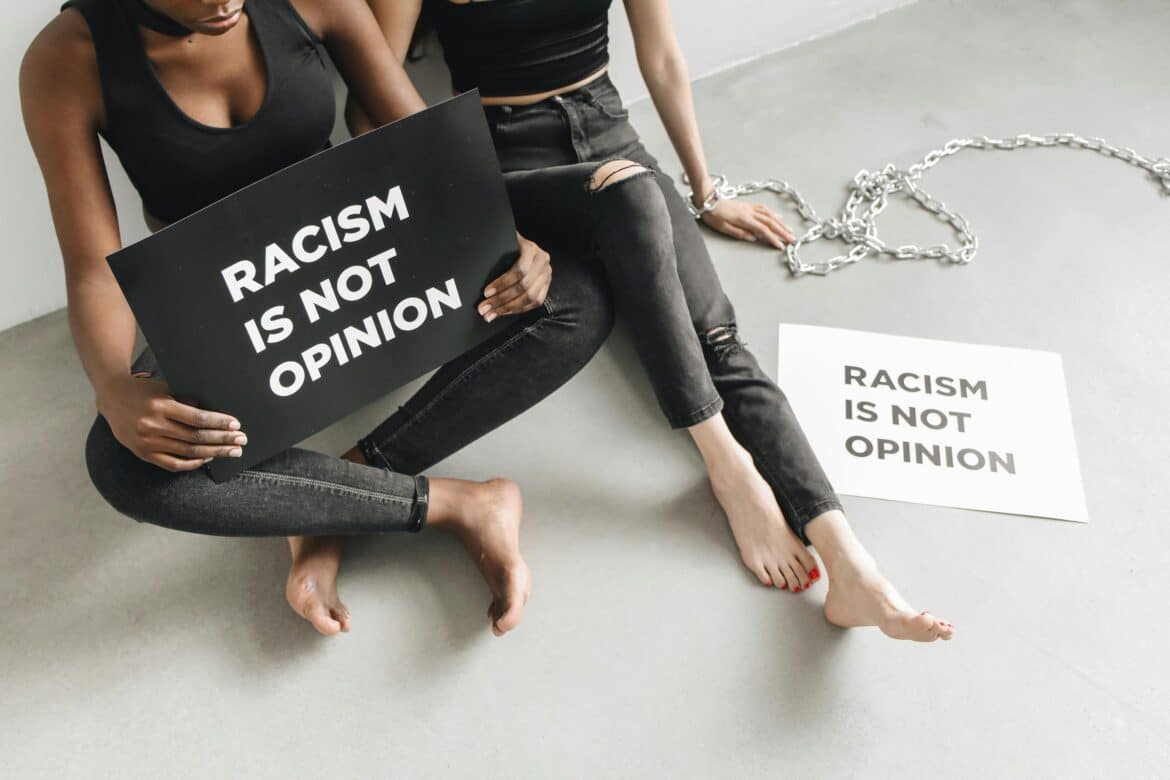 Women with placards saying racism is not opinion