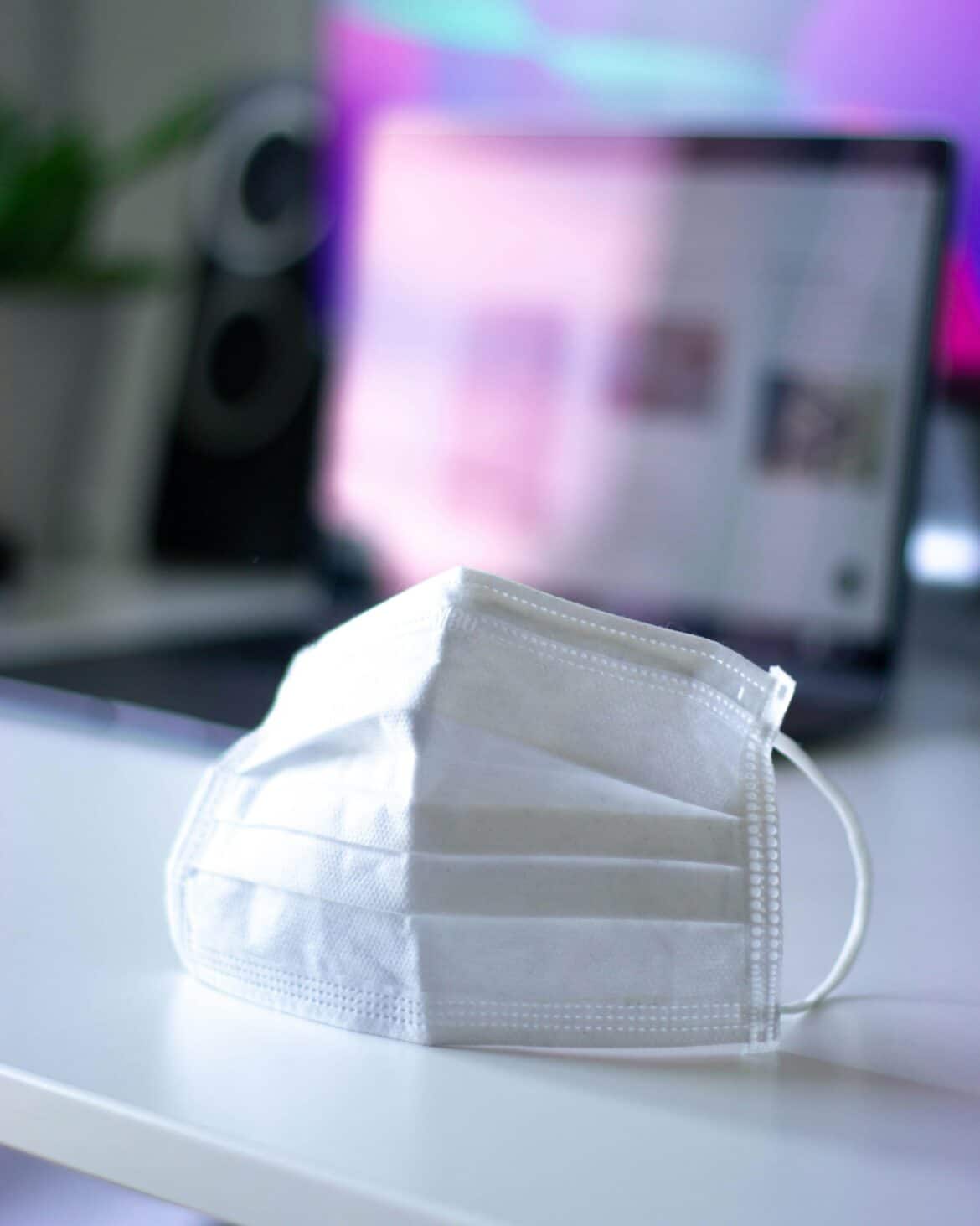 A face-mask in front of a modern desk setup