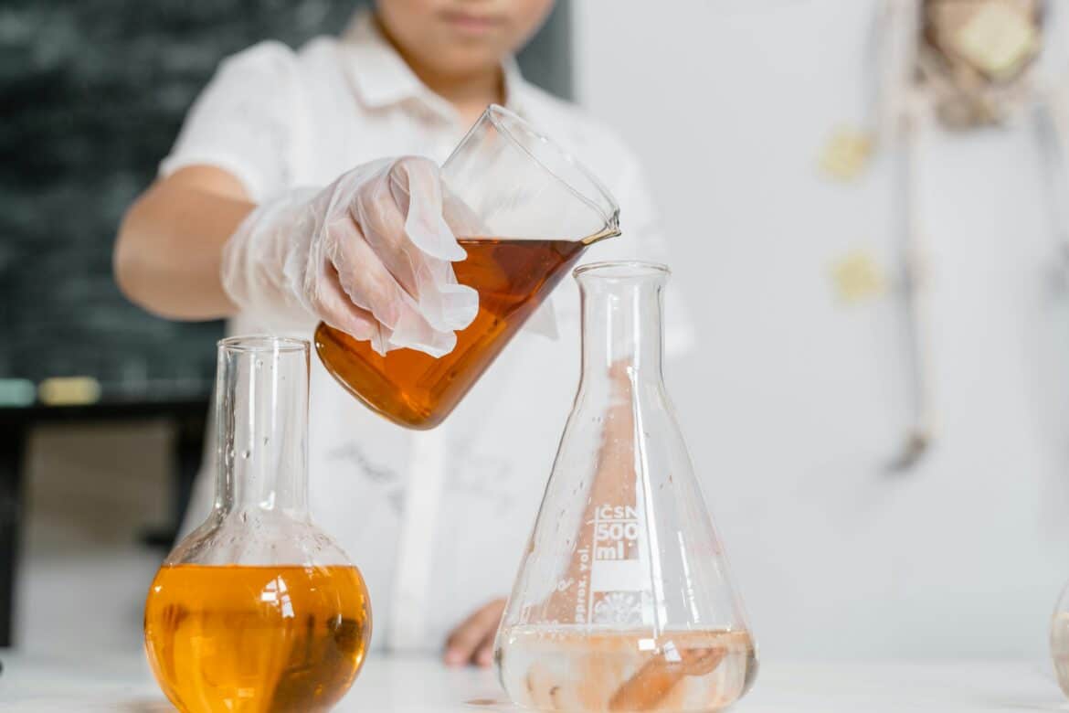 A person pouring liquid in a flask