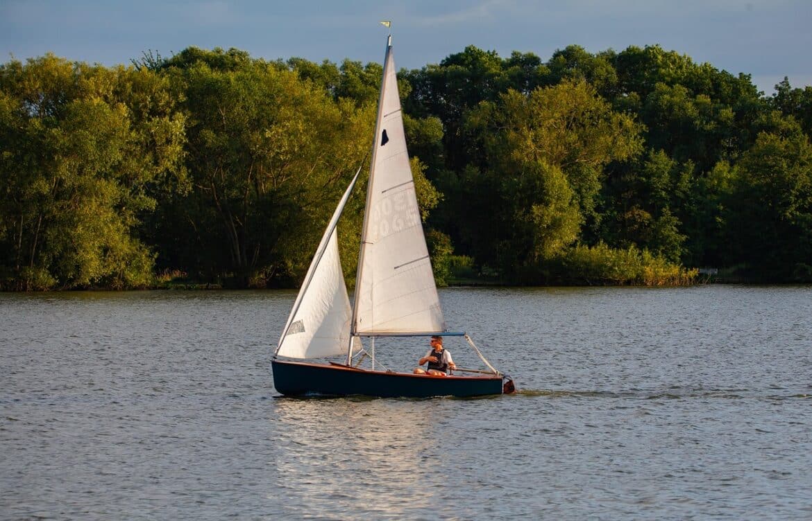 small boat, single crew boat, man in boat, boat, lake, river, boat on lake, reflection, evening, travel, trees, pleasure craft, sail boat, sailing, landscape, outdoors, water, tourism, relaxation, nature, scenic